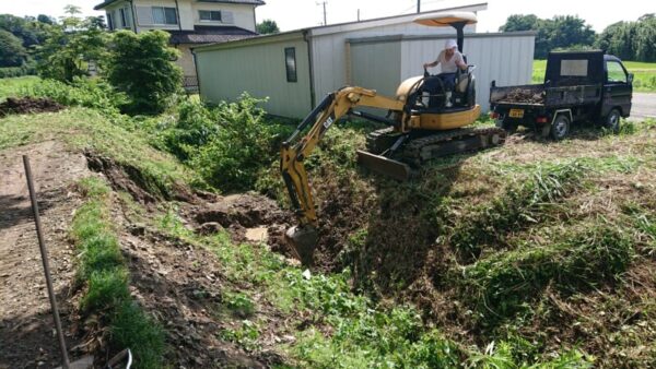 排水路を塞いだ土砂崩れの現場の復旧工事